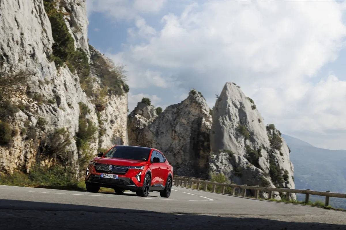 Renault Rafale rouge sur une route de montagne au pied de falaises calcaires