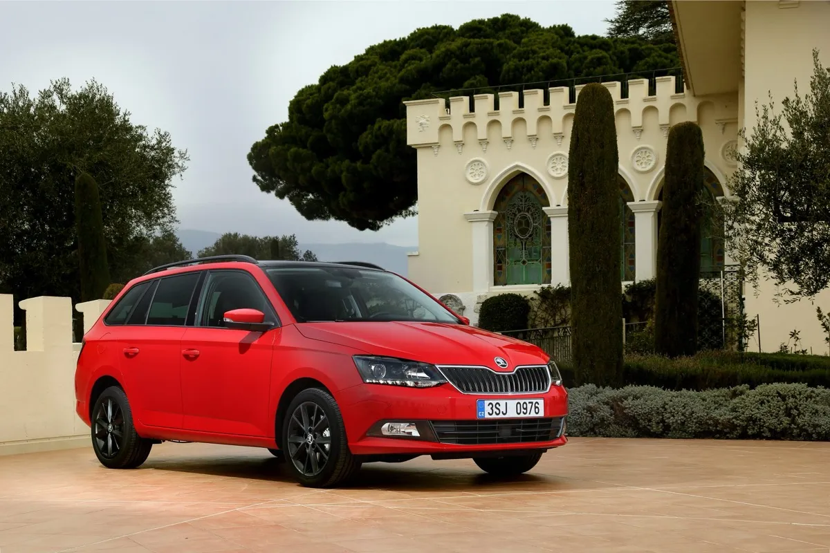 Skoda Fabia Combi de troisième génération rouge, version break, vue de trois quarts avant devant une bâtisse crénelée