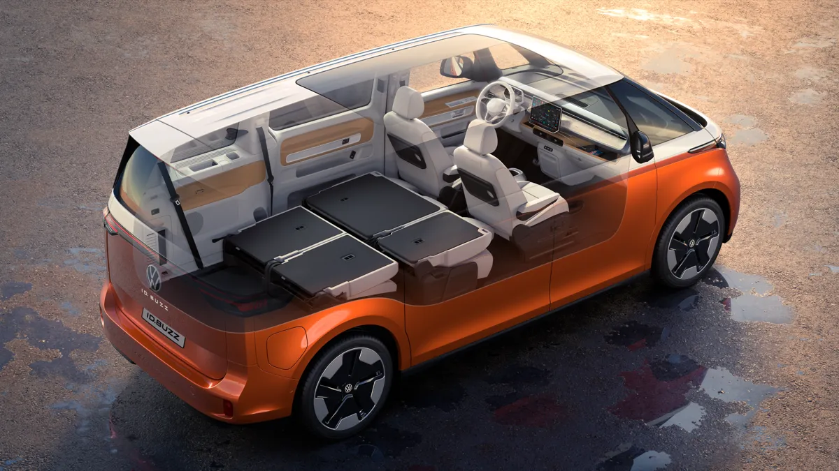 Vue en transparence d’un Volkswagen ID. Buzz long orange montrant ses trois rangées de sièges, deuxième et troisième rangs rabattus