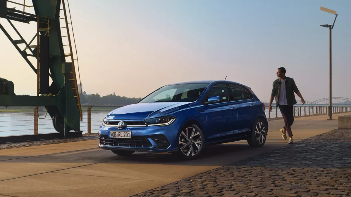 Volkswagen Polo bleue garée sur un quai au bord d’un fleuve, vue de trois quarts avant